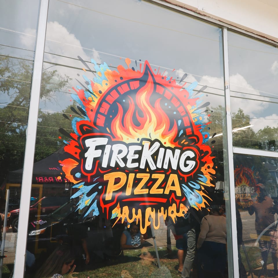 The colorful Fire King Pizza logo painted on the storefront window.