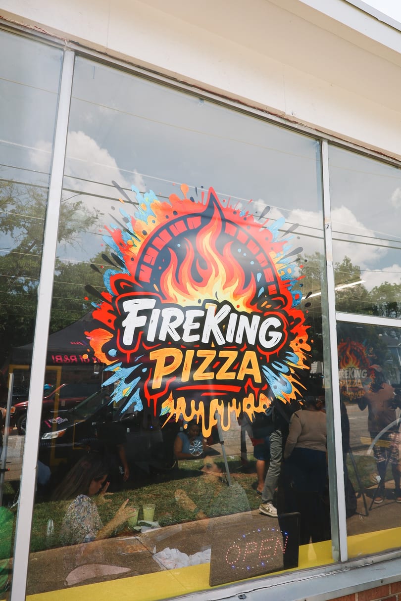 The colorful Fire King Pizza logo painted on the storefront window.