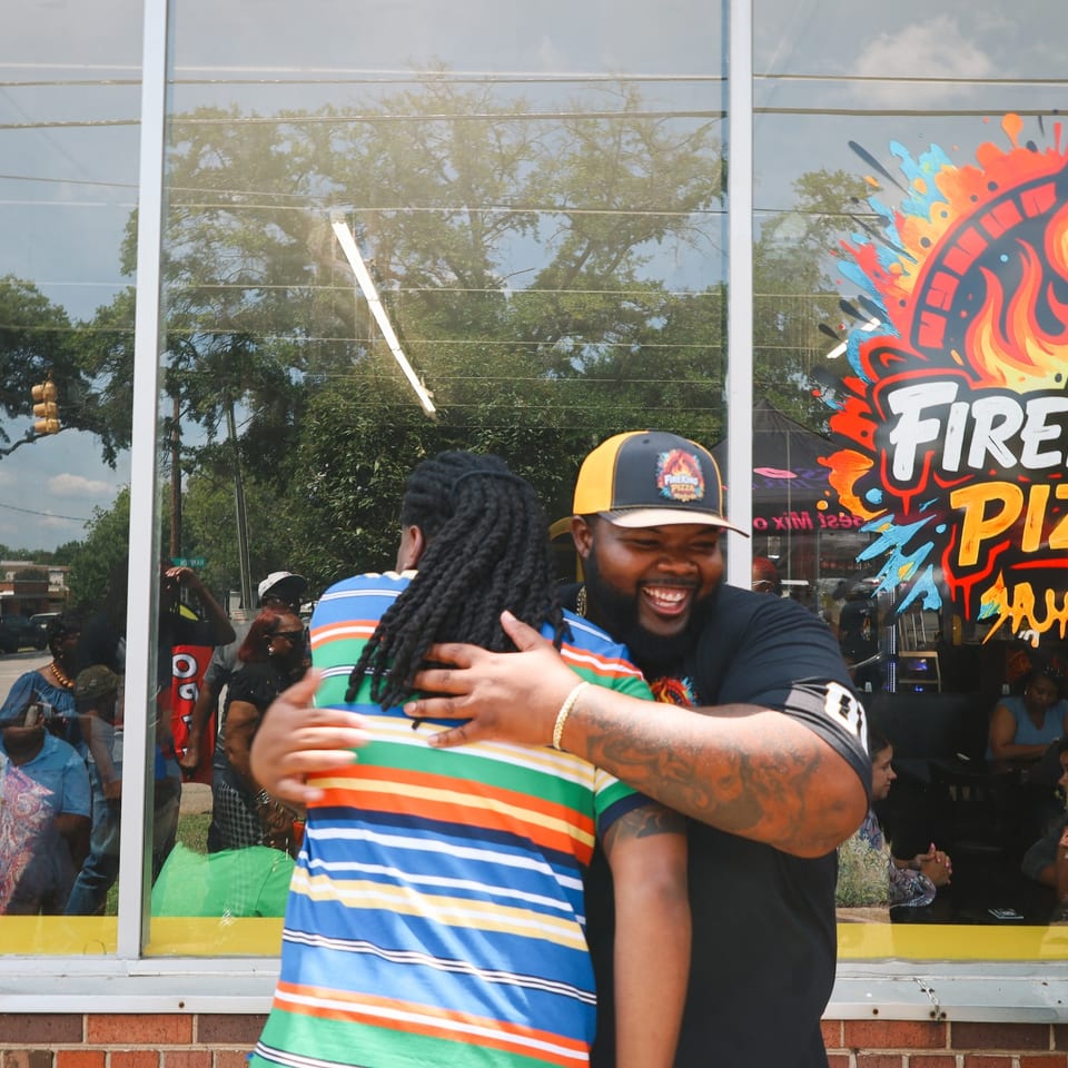 A Fire King owner laughing and hugging a guest during the celebration.