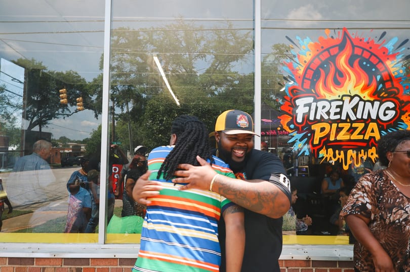 A Fire King owner laughing and hugging a guest during the celebration.