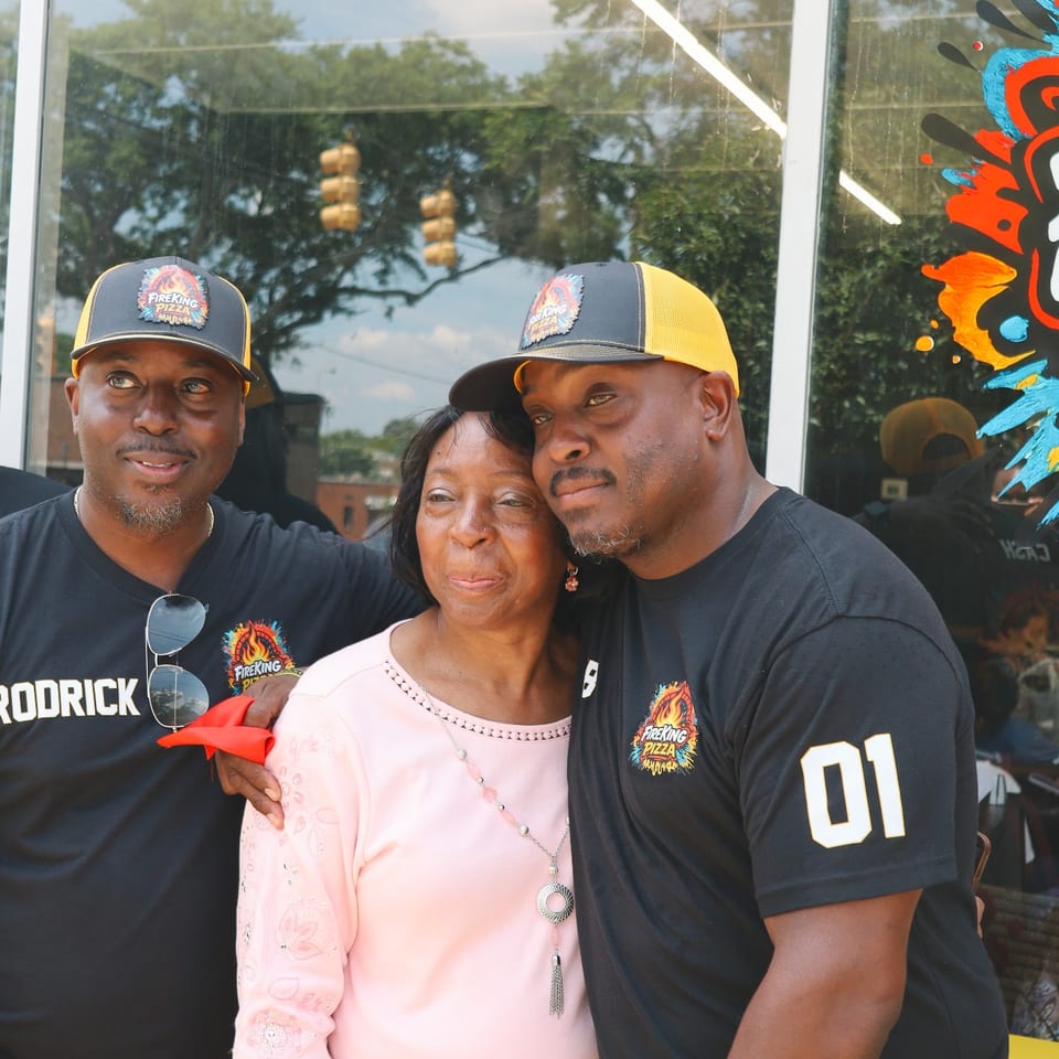 Two of the Fire King owners posing with their mother outside the shop.