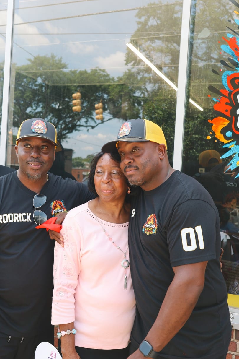 Two of the Fire King owners posing with their mother outside the shop.