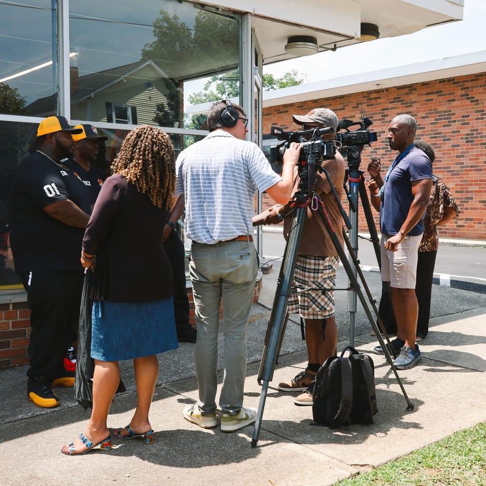 Local news crew filming an interview with the Fire King team on opening day.