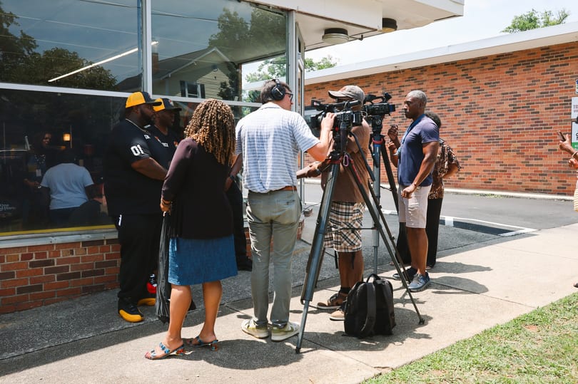 Local news crew filming an interview with the Fire King team on opening day.